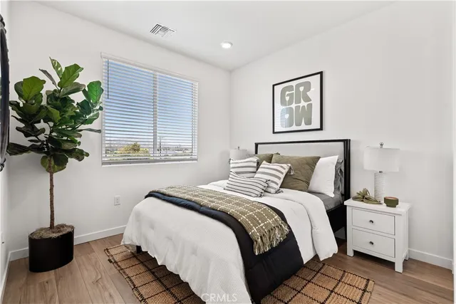 a bedroom with a bed potted plant and a window