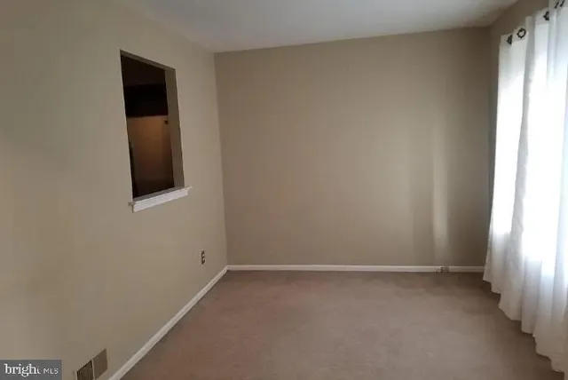 a view of a small space with wooden floor and a window