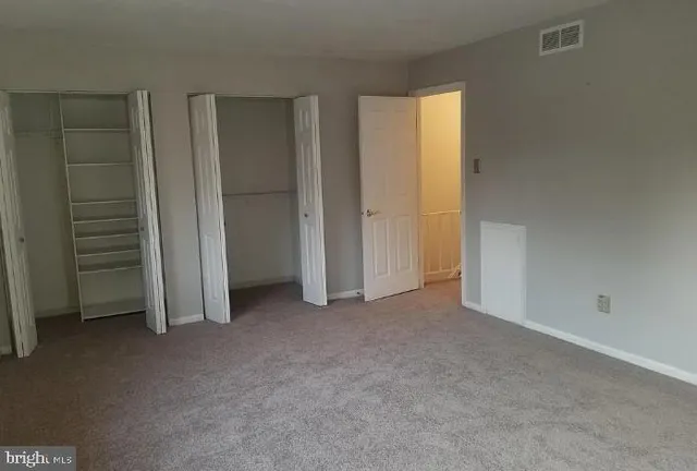 an empty room with closet and a window