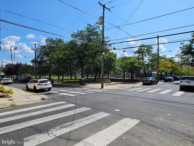 a view of a city street with parked cars