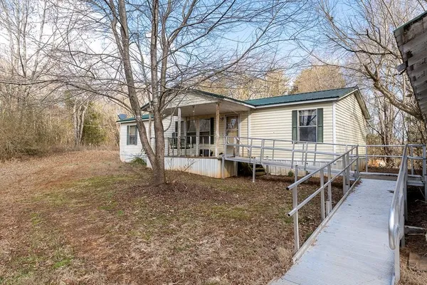 a view of a house with backyard and trees