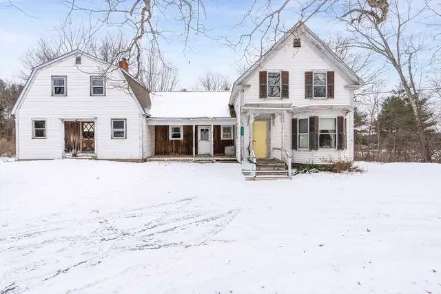 a front view of a house with a yard covered in snow