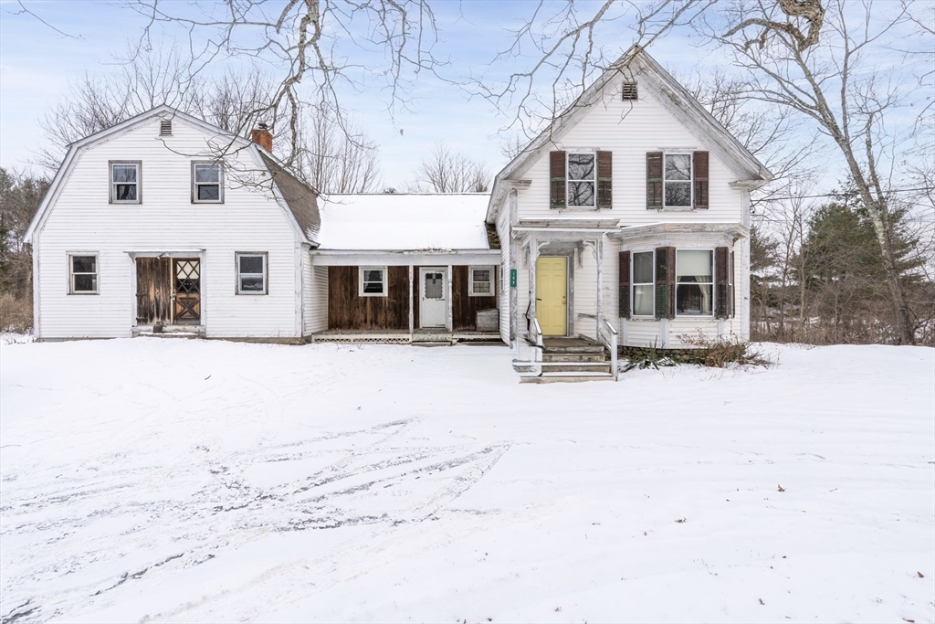 a front view of a house with a yard covered in snow