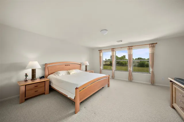 a bed sitting in a room next to a lamp