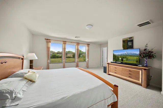 a bedroom with a large bed and a flat screen tv