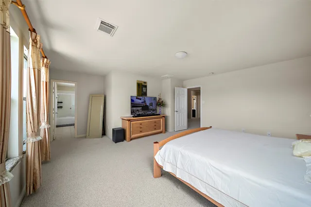 a bedroom with a bed furniture and a flat tv screen