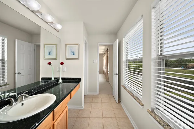 a bathroom with a granite countertop sink and a mirror