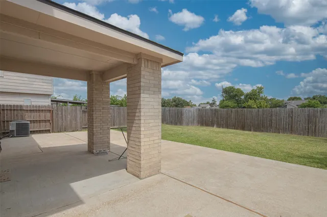 a view of a backyard with brick wall and fence