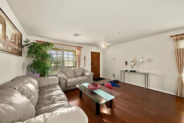 a living room with furniture and a wooden floor