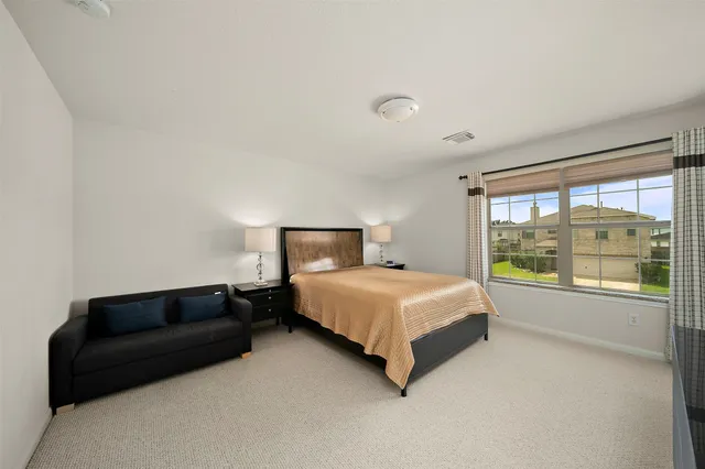 a bedroom with a bed and a large window