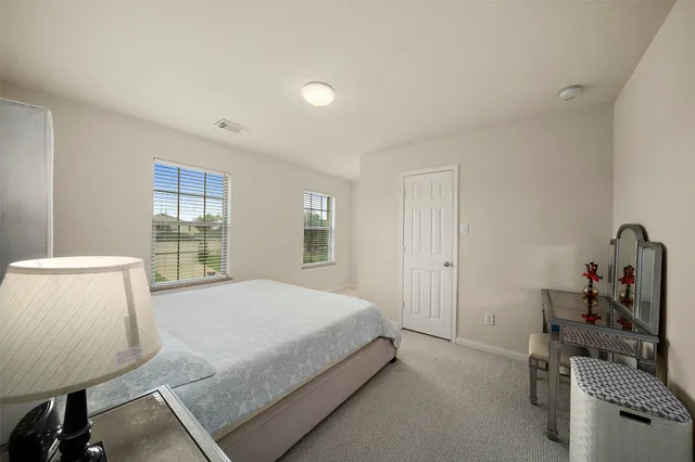 a bedroom with a bed and large windows