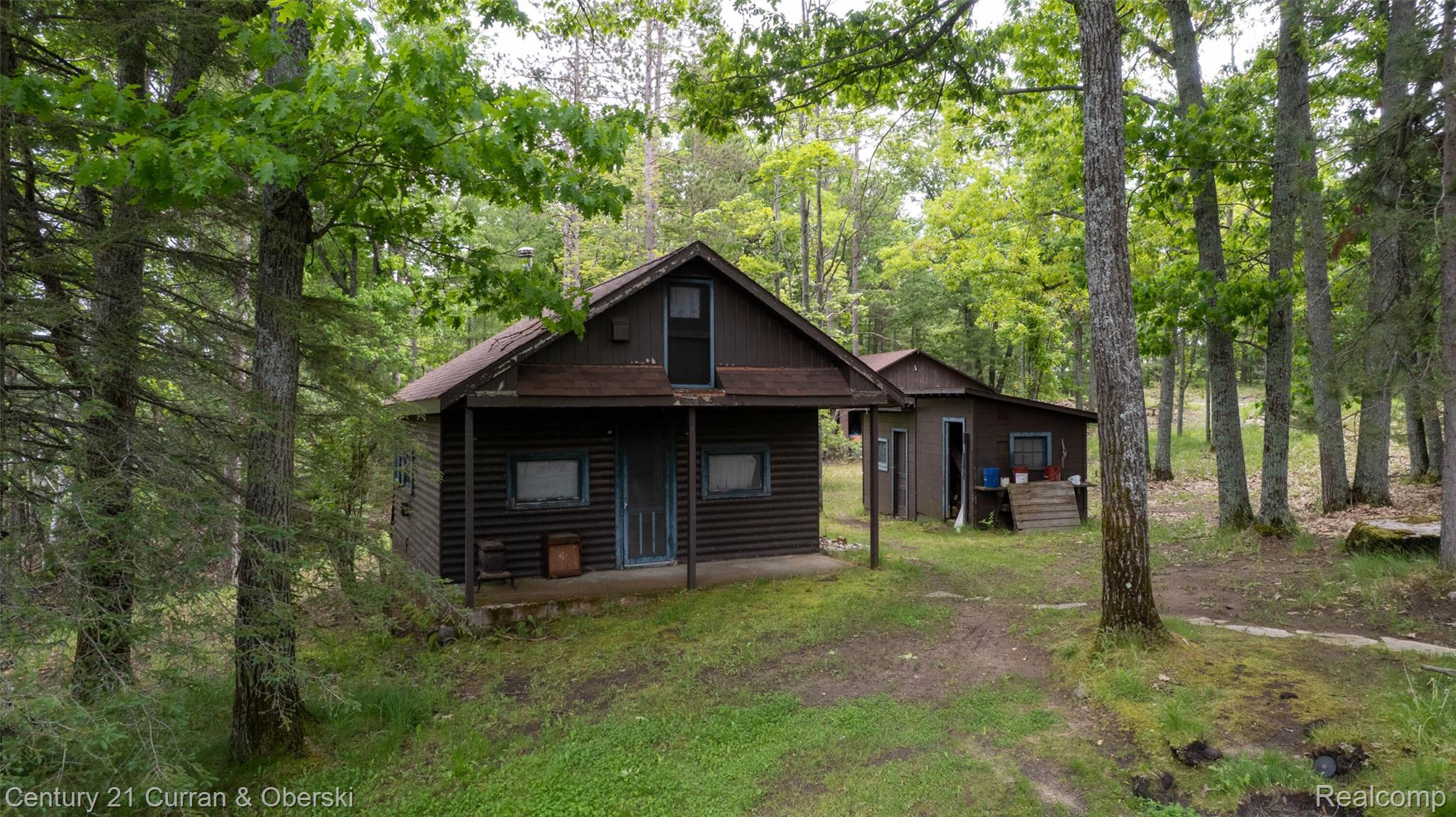 8775 Winding Rdg Drive Millersburg, MI 49759 - Photo 12 of 53 Wood-sided cabin featuring a covered porch and an upper-level window