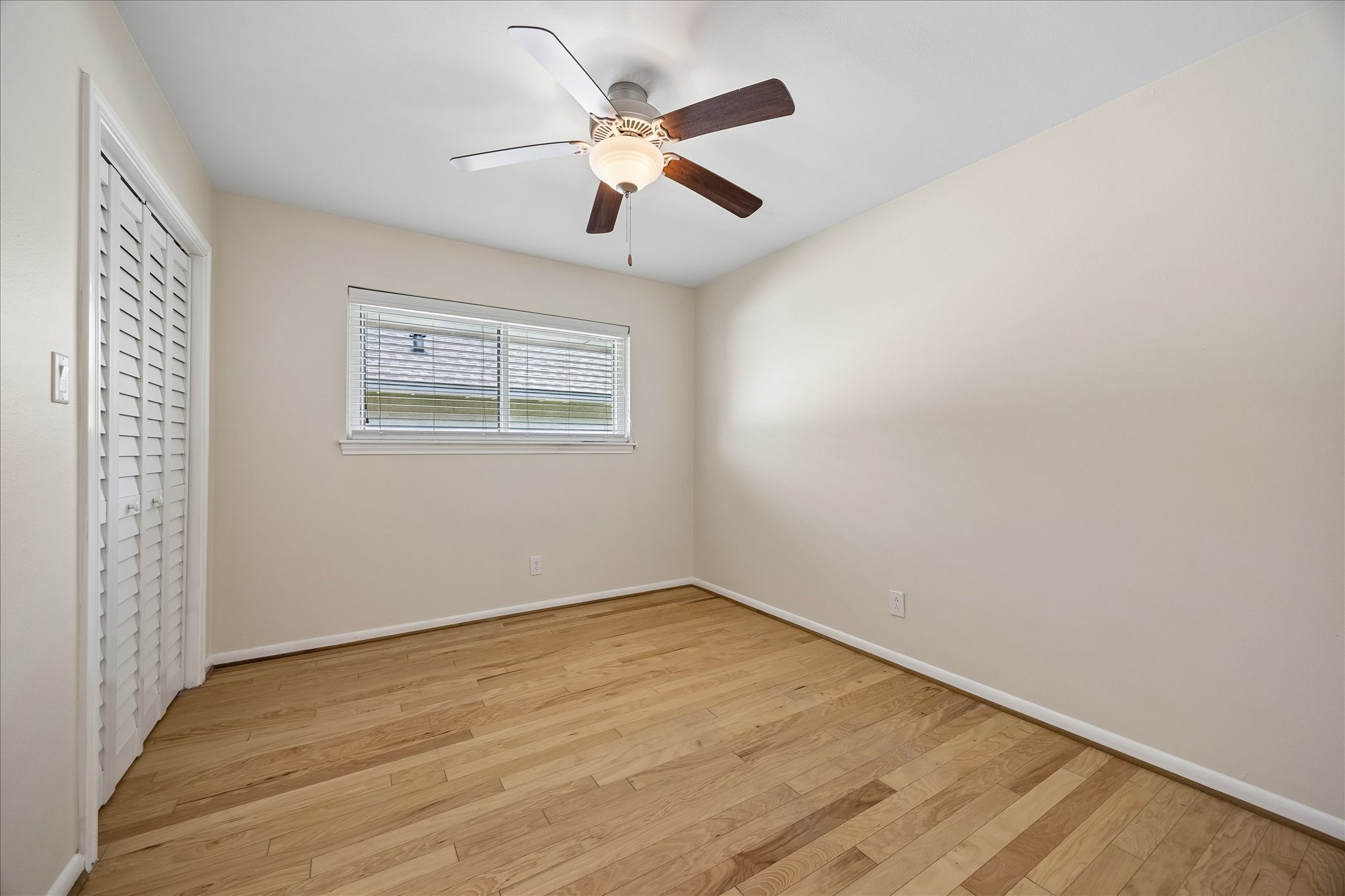 8922 Springview Lane Houston, TX 77080 - Photo 18 of 22 an empty room with wooden floor ceiling fan and windows