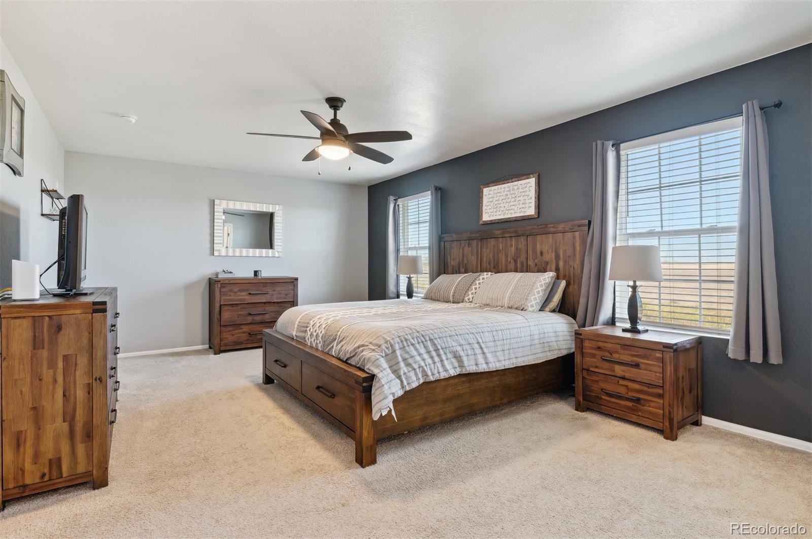 2328 Ruby Avenue Brighton, CO 80603 - Photo 13 of 21 a spacious bedroom with a bed a chandelier and dresser