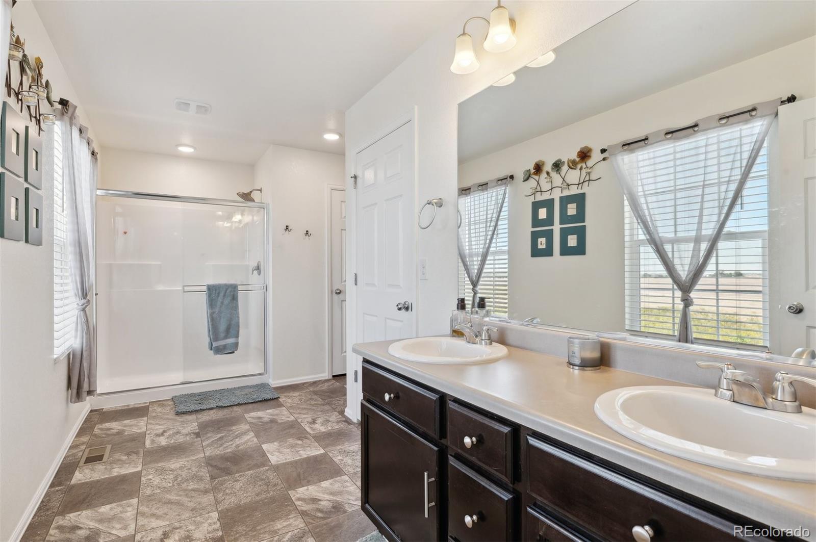 2328 Ruby Avenue Brighton, CO 80603 - Photo 15 of 21 a spacious bathroom with a double vanity sink mirror and shower