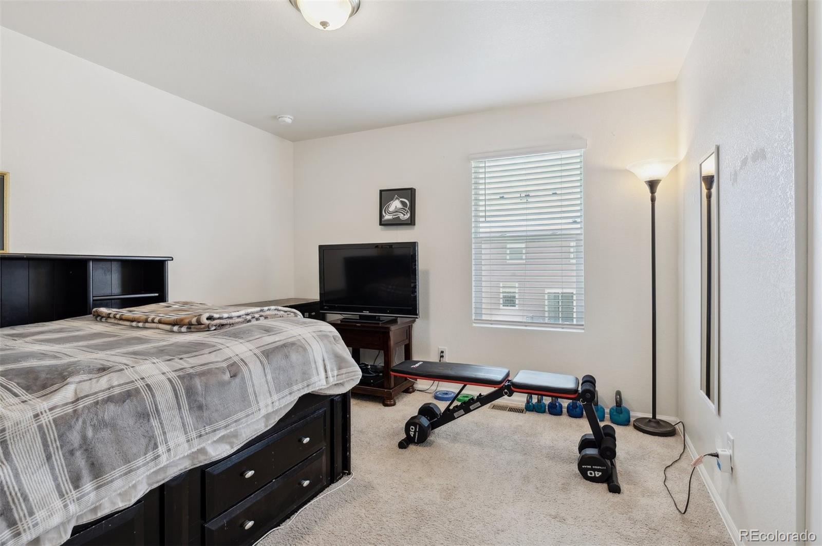 2328 Ruby Avenue Brighton, CO 80603 - Photo 18 of 21 a bedroom with a bed and a tv on table