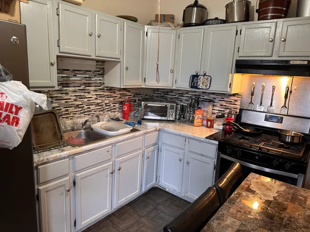 a kitchen with stainless steel appliances a stove a sink and cabinets