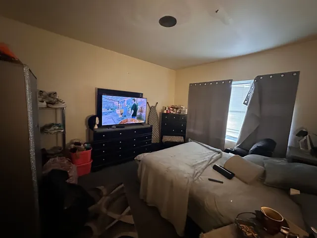 a bedroom with furniture and a flat screen tv