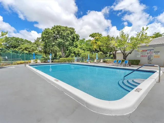 a view of a swimming pool with a yard and sitting space