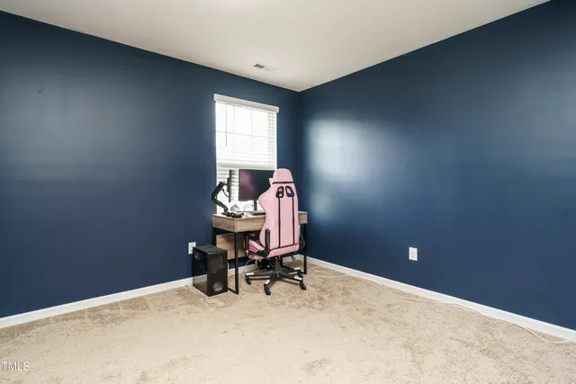 a view of a workspace with furniture and a window