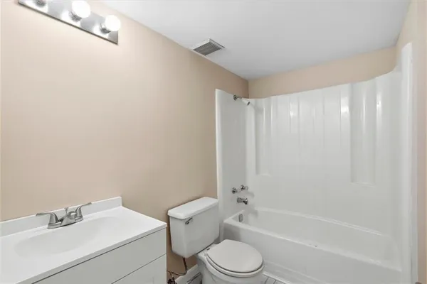 a bathroom with a white toilet a sink and a bathtub
