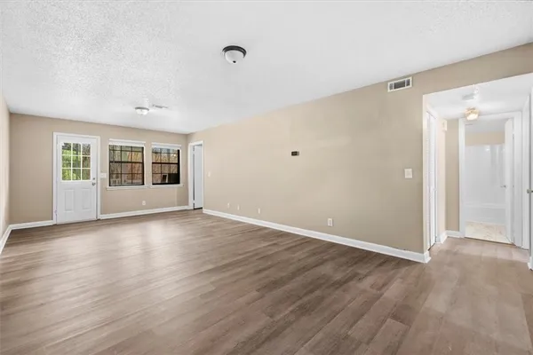 a view of a livingroom with wooden floor and windows