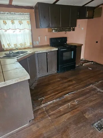 a kitchen with kitchen island a stove and a sink