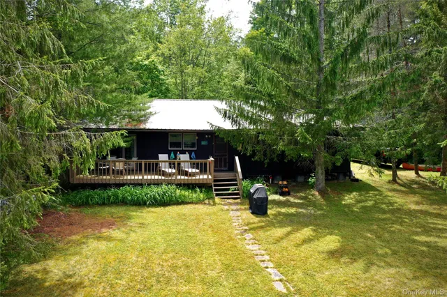 a view of a swimming pool with chairs and a small yard