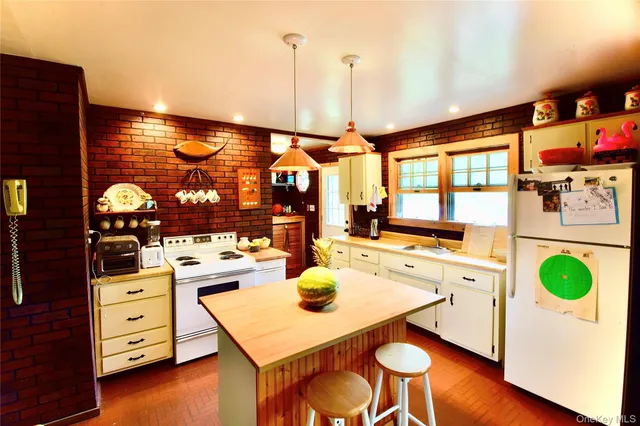 a kitchen with a stove a refrigerator and a dining table with wooden floor
