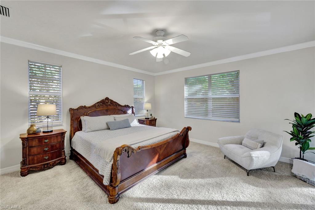 7830 Twin Eagle Lane Fort Myers, FL 33912 - Photo 16 of 31 a bedroom with a bed and a chandelier