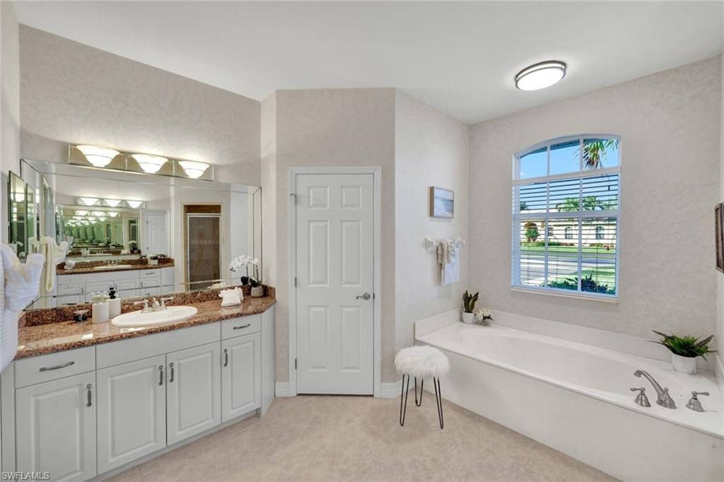 7830 Twin Eagle Lane Fort Myers, FL 33912 - Photo 20 of 31 a spacious bathroom with a tub sink and mirror