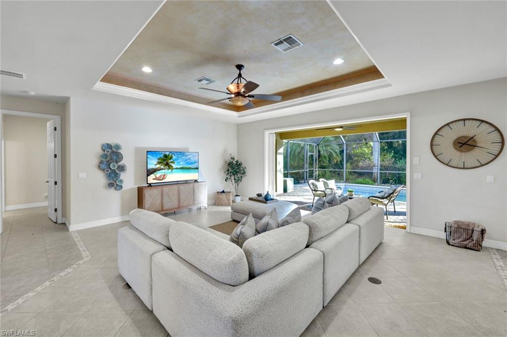7830 Twin Eagle Lane Fort Myers, FL 33912 - Photo 7 of 31 a living room with furniture a large window and a chandelier