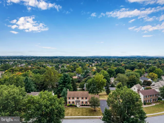 an aerial view of a house with lots of residential buildings ocean and mountain view in back