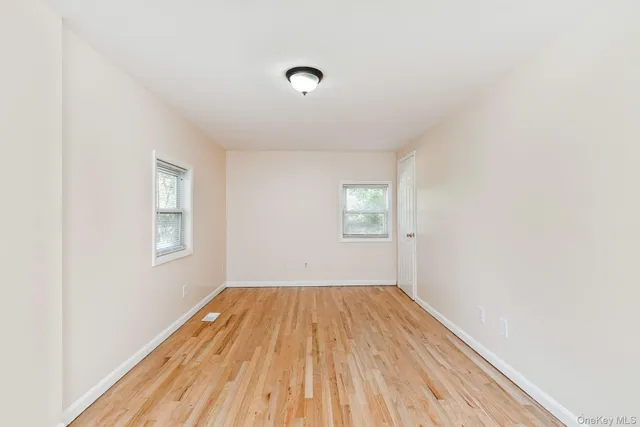 a view of a room with wooden floor and windows