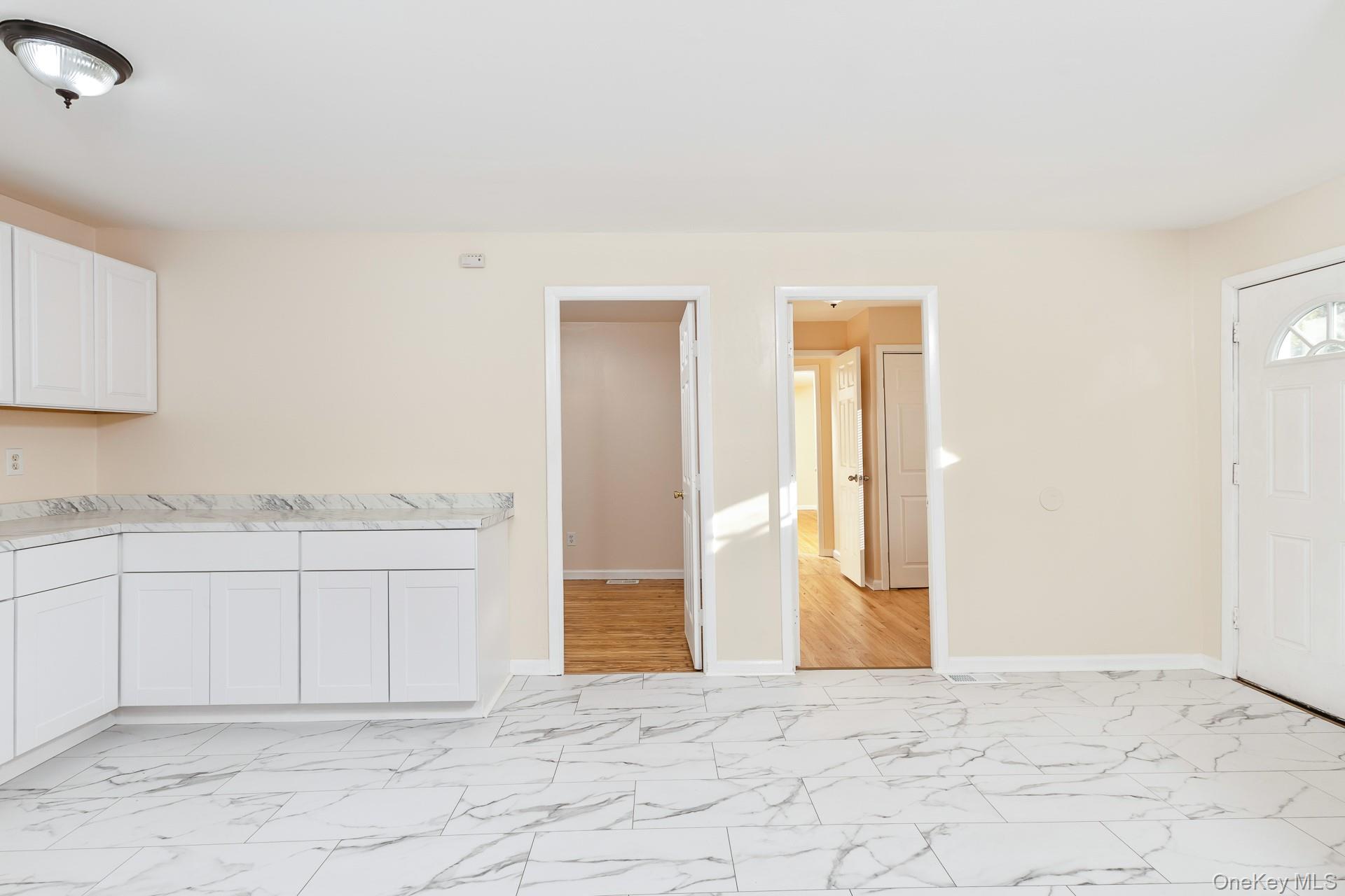 860 Flanders Road Flanders, NY 11901 - Photo 4 of 31 Kitchen featuring white cabinets, light marble finish floors, and light countertops
