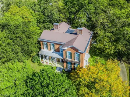 a aerial view of a house with swimming pool and large trees