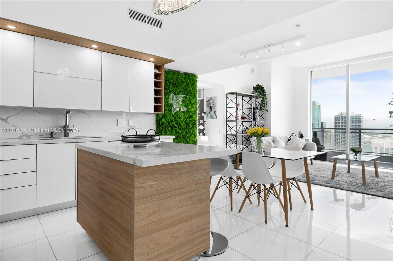 a kitchen with stainless steel appliances kitchen island granite countertop a table chairs and a refrigerator