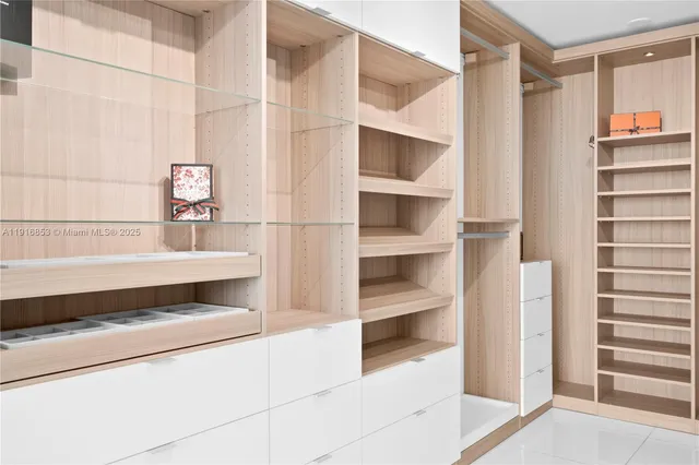 a view of walk in closet with clothes and shoes