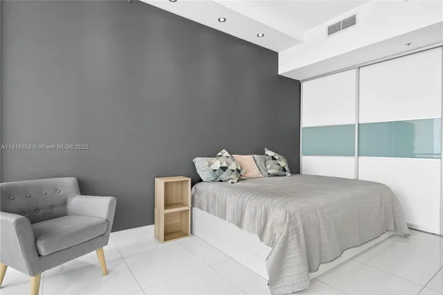 a bedroom with a bed a couch and window