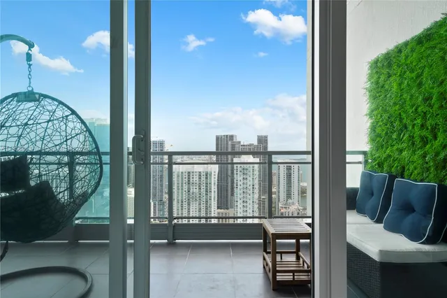 a living room with couches and a dining table with garden view
