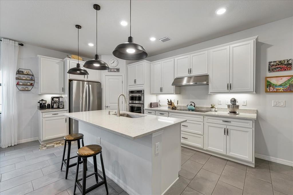 8258 Northwest 79th Avenue Tamarac, FL 33321 - Photo 13 of 38 a kitchen with kitchen island a stove a table and chairs in it