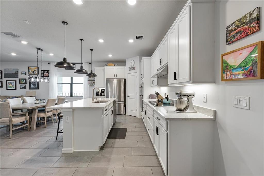 8258 Northwest 79th Avenue Tamarac, FL 33321 - Photo 14 of 38 a kitchen with kitchen island granite countertop a sink a counter top space appliances and cabinets