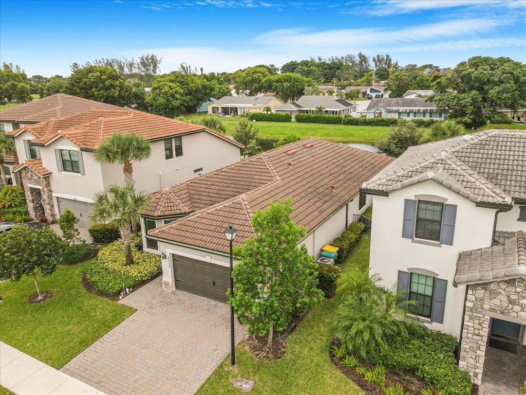 8258 Northwest 79th Avenue Tamarac, FL 33321 - Photo 3 of 38 a view of a house with a yard and table and chairs under an umbrella