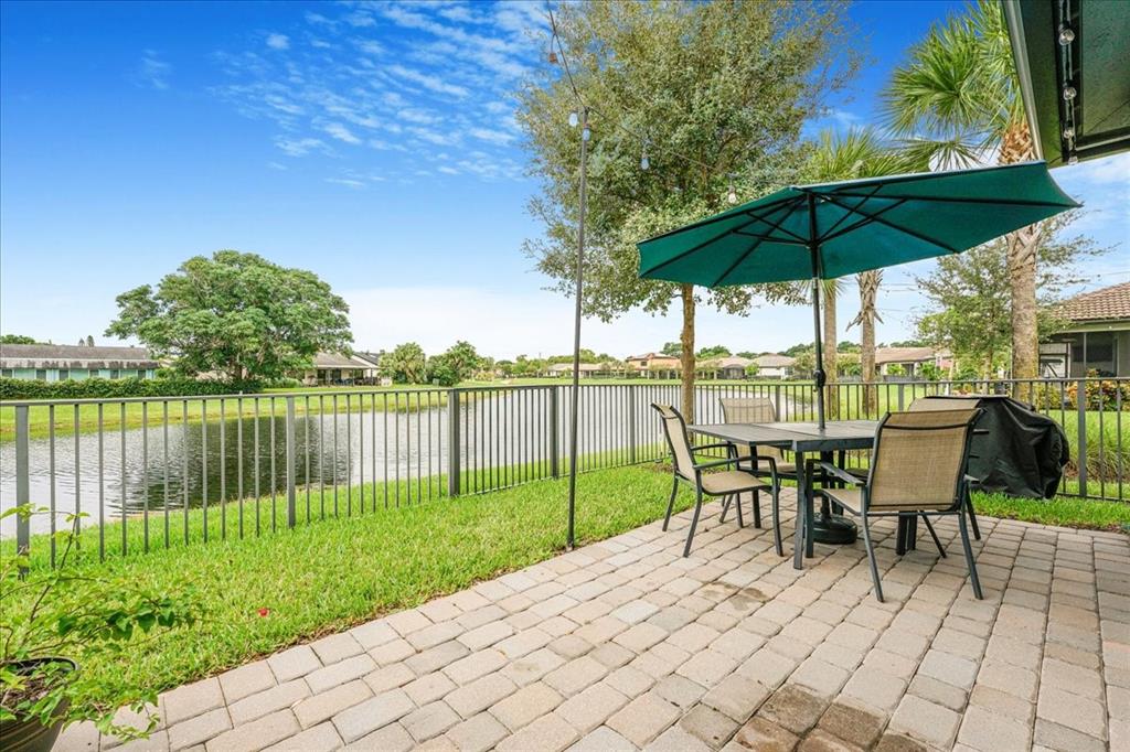 8258 Northwest 79th Avenue Tamarac, FL 33321 - Photo 32 of 38 a view of a back yard with a table and chair under an umbrella
