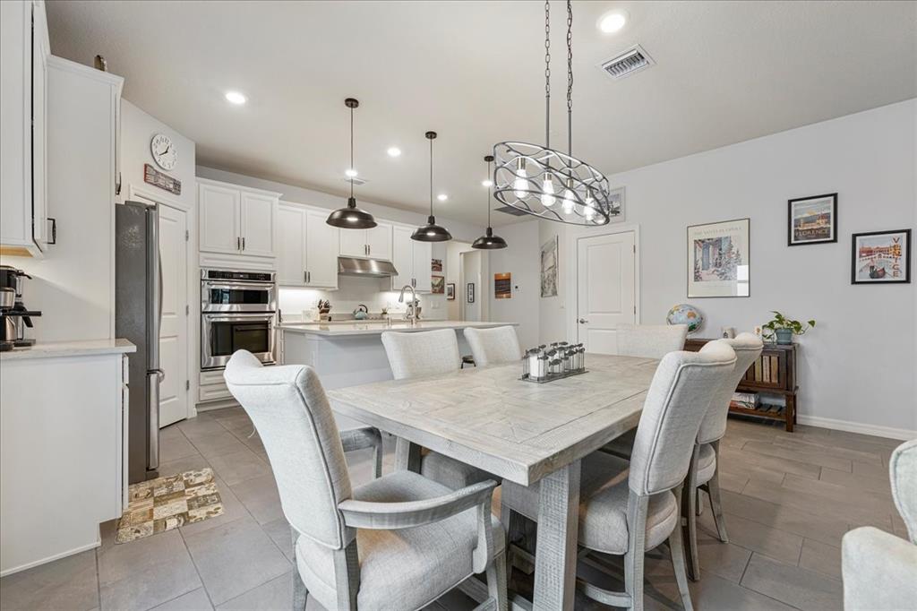 8258 Northwest 79th Avenue Tamarac, FL 33321 - Photo 34 of 38 a dining room with stainless steel appliances kitchen island granite countertop a dining table chairs and a refrigerator