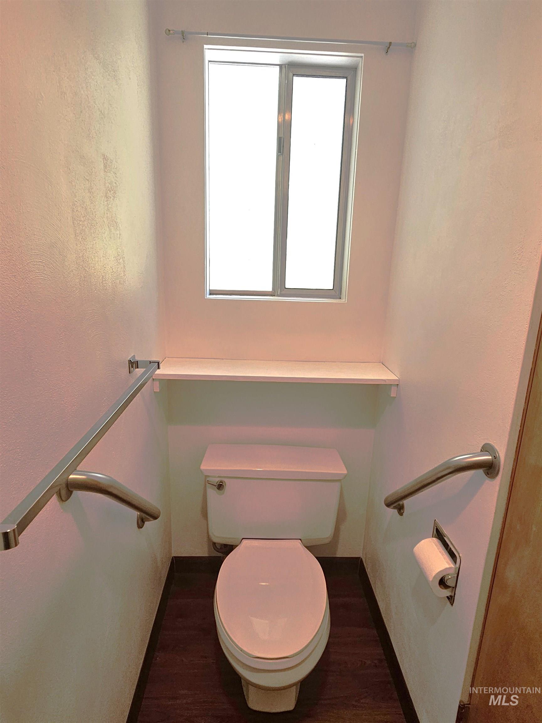 29865 Mission Creek Road Culdesac, ID 83524 - Photo 14 of 43 Dedicated water closet featuring a toilet, wood-finish flooring, a functional window, and stainless steel grab bars