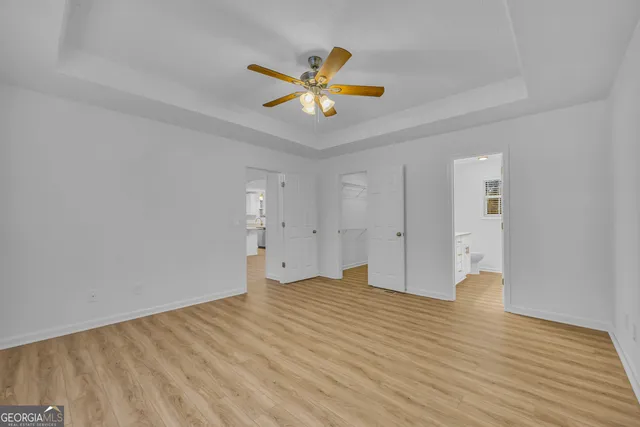a view of an empty room with window and wooden floor
