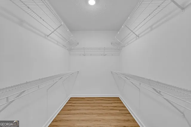a view of a room with wooden floor and white door
