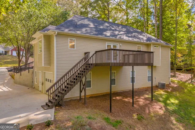 a view of a house with a wooden deck and a yard