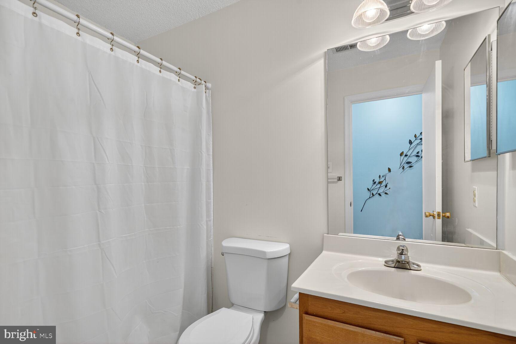 14101 Valleyfield Drive, Unit 114 Silver Spring, MD 20906 - Photo 11 of 26 a bathroom with a sink a mirror and a toilet